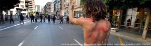 Espalda de un huelguista que desafía a lo antimotines en Valencia Foto: El País