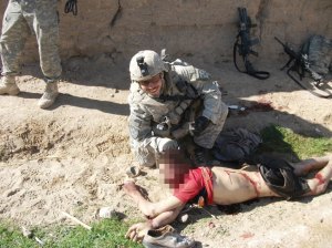 Capitán del ejército norteamericano Jeremy Morlock posa sonriente mientras sostiene por el pelo la cabeza de un campesino afagano asesinado por el "Kill Team"