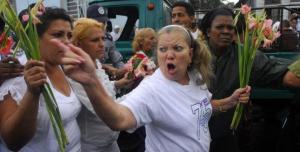 La ura Pollán "líder" de las "Damas de blanco" enarbola un gladiolo en las calles de La Habana