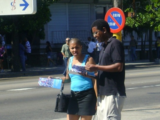 Cubanos leen folleto con Lineamientos para el desarrollo económico y social del Partido y la Revolución en la Habana, Cuba 
